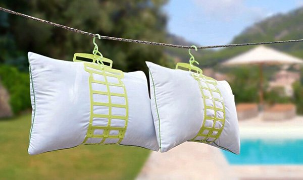 A pair of bamboo pillows drying on the line using a pillow drying rack