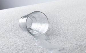 Spilled glass of water on an waterproof mattress protector