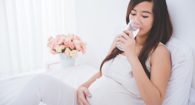 Pregnant woman drinking fluid just before bedtime