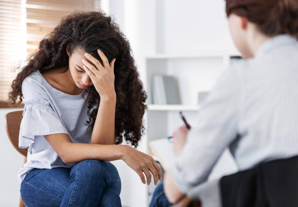 A young woman suffering with PTSD talking to a professional psychiatrist