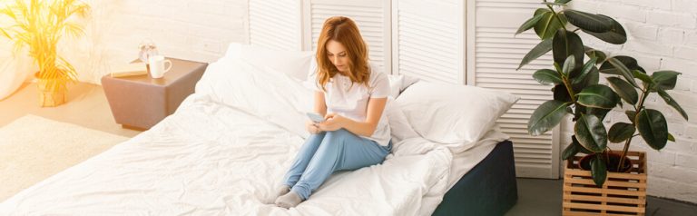 A girl resting on a bed with organic white bedding