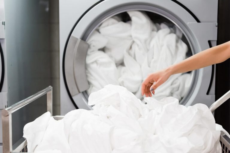 Laundry: White sheets being taken out of the washing machine