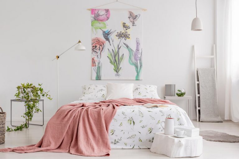 Bright, peach and white bedroom, green plants, animal themed bedding.