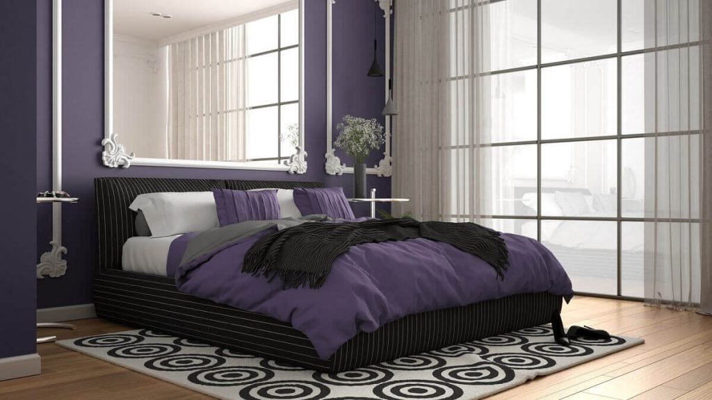 Modern violet colored bedroom in classic room with wall moldings, parquet, double bed with duvet and pillows, minimalist bedside tables, mirror and decors