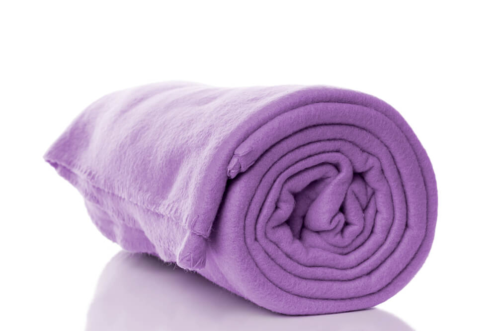 A purple colored fleece fabric blanket