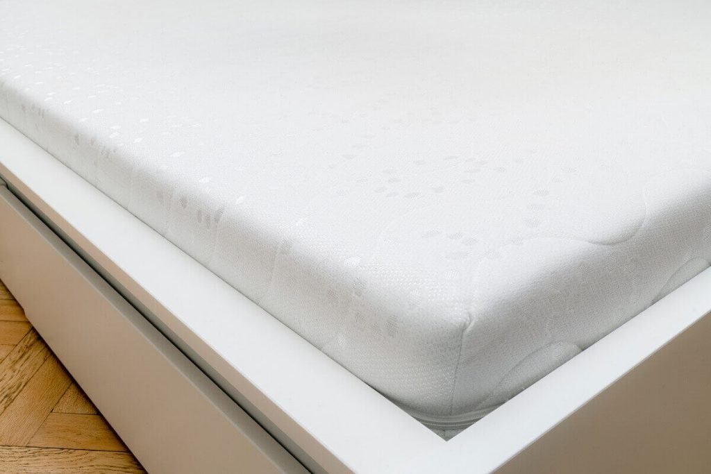 A clean, bright and new memory foam mattress on a bed frame