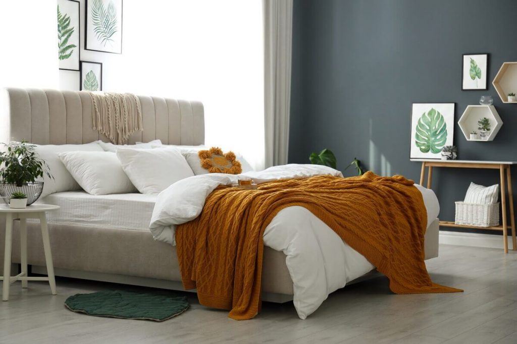 Big Comfortable bed with extra pillows, throw blankets to hide a bed frame.