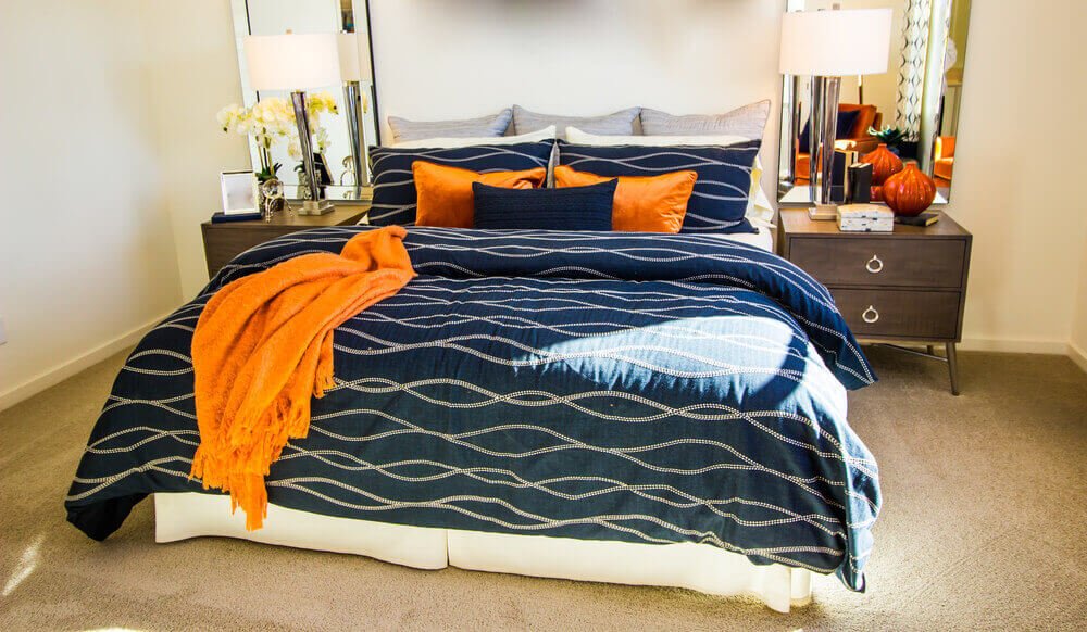 A modern bedroom, oversized blankets, bedskirt to hide bed frame and nightstands