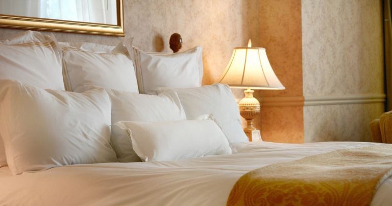 Luxurious bed with egyptian cotton bed sheets and pillows gold theme decor
